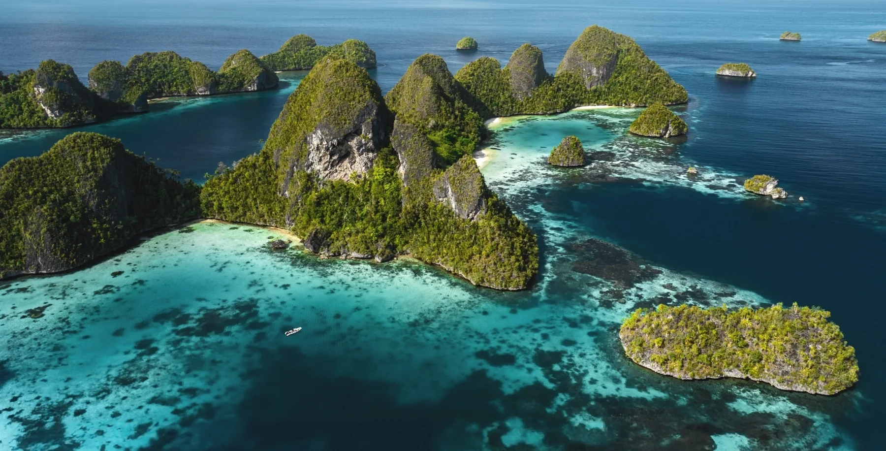 Forested limestone islands surrounded by turquoise water in Raja Ampat